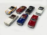 several toy cars are lined up in a row on a white surface