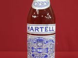 an empty bottle of martelli on a red background