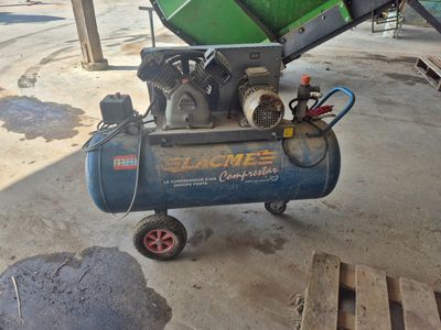 un petit compresseur d'air posé sur un chariot dans un garage