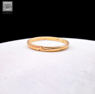 a close up of a gold ring sitting on top of a white surface