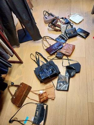 il y a beaucoup de sacs et de sacs à main par terre dans cette pièce