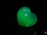 un objet vert en forme de cœur posé sur une surface noire