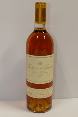 Des bouteilles de vin sont posées sur une surface blanche, devant un fond blanc.