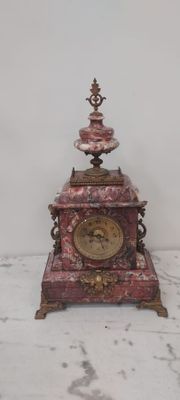 une petite horloge posée sur une table en marbre