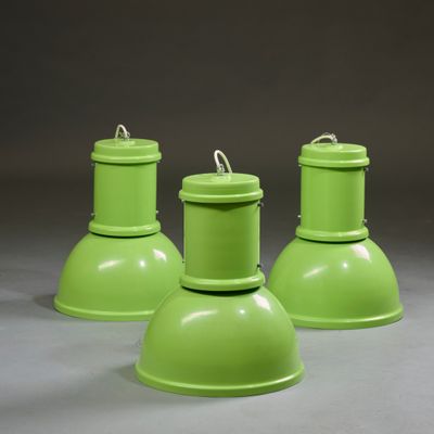 trois lampes métalliques vertes posées sur une surface grise