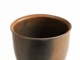 a brown cup sitting on top of a white table
