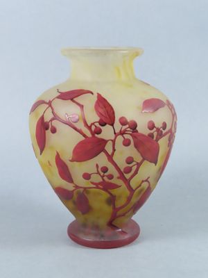 a yellow vase with red flowers on it on a white background
