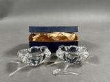 une paire de bougeoirs en verre transparent, dans une boîte bleue posée sur une table