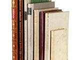 several old books are stacked on top of each other on a white surface