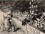 photo en noir et blanc d'une femme assise devant un magasin