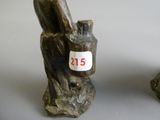 two figurines of a bird sitting on a tree stump
