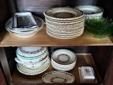 many plates and bowls on a shelf in a room