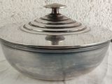 a large metal pot with a lid on a table