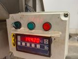 a clock on the side of a machine in a kitchen
