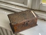 une petite boîte en bois posée sur le rebord d'une fenêtre
