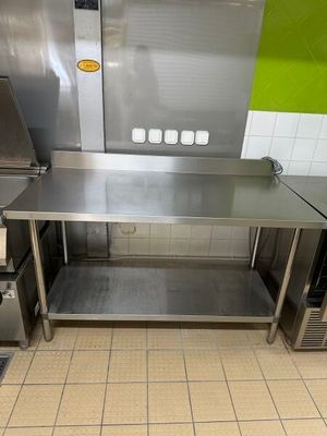 une grande cuisine en inox avec un mur végétal