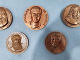 four different types of bronze coins on a blue surface