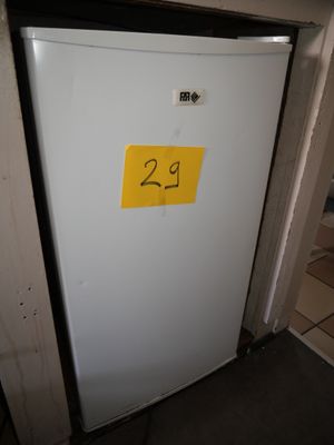 un réfrigérateur blanc sur lequel est collé un autocollant jaune