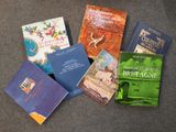 Plusieurs livres sont posés par terre, les uns à côté des autres.