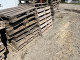 several pallets of wood are stacked on the ground in front of a building