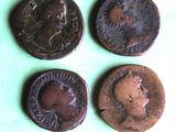 three old roman coins sitting on top of a green surface