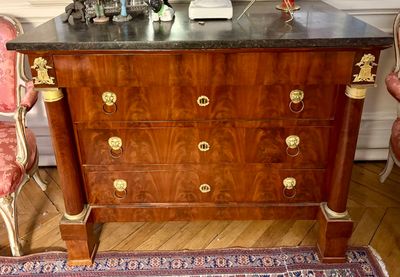 une commode en bois avec un plateau en marbre dans une chambre