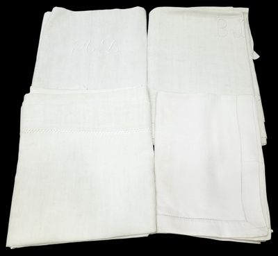 trois serviettes blanches sont pliées les unes sur les autres sur une surface noire