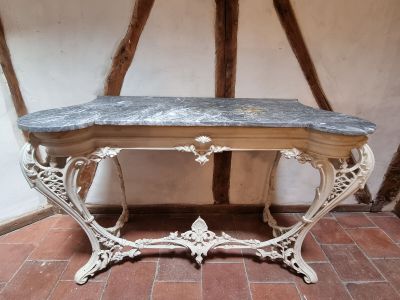 a table with a marble top on a brick floor