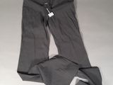 Le pantalon est gris et comporte une étiquette blanche.