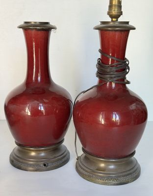 deux vases rouges posés l'un à côté de l'autre sur une table