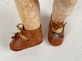 a close up of a person ' s feet wearing brown shoes