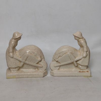 paire de figurines en céramique blanche représentant un homme et une femme assis sur une tortue