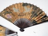 two asian fans on the wall with designs on them