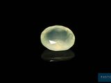 a close up of a yellow jade stone on a black surface