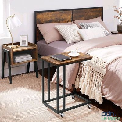 un lit avec une tête de lit en bois et une table sur laquelle est posée une lampe
