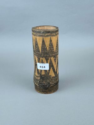 un vieux vase orné d'un motif, posé sur une table