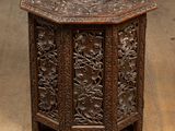 une table ancienne en bois ornée de sculptures, dans une pièce
