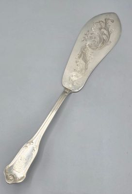 une cuillère en argent ornée d'un motif, posée sur une table