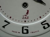 une horloge blanche avec des chiffres noirs et un oiseau dessus