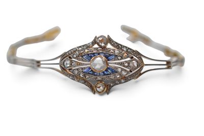 un gros plan sur un bracelet manchette orné d'un diamant et d'une perle