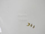a close up of a white plate with gold writing on it