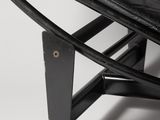black leather lounge chair with metal frame and foot rest on a white background