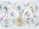 several plates with floral designs are arranged on a white surface