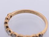 a close up of a yellow gold ring with black diamonds