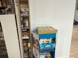 a blue book shelf with games on it in the corner of a room