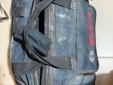 a blue duffel bag sitting on the floor next to a pair of scissors