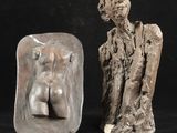 deux sculptures représentant un homme et une femme sur fond noir