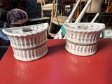 une paire de vases en céramique blancs et rouges posés sur une table rouge