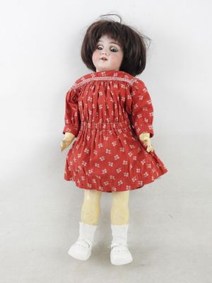 une image représentant une poupée vêtue d'une robe rouge et de collants jaunes