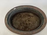 a metal bowl with a hole in it on a white surface